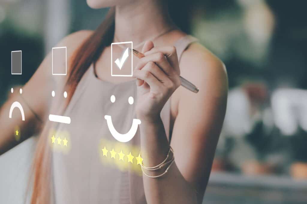 Female creating a smiley face on a digital display, fostering customer connections for brand loyalty.